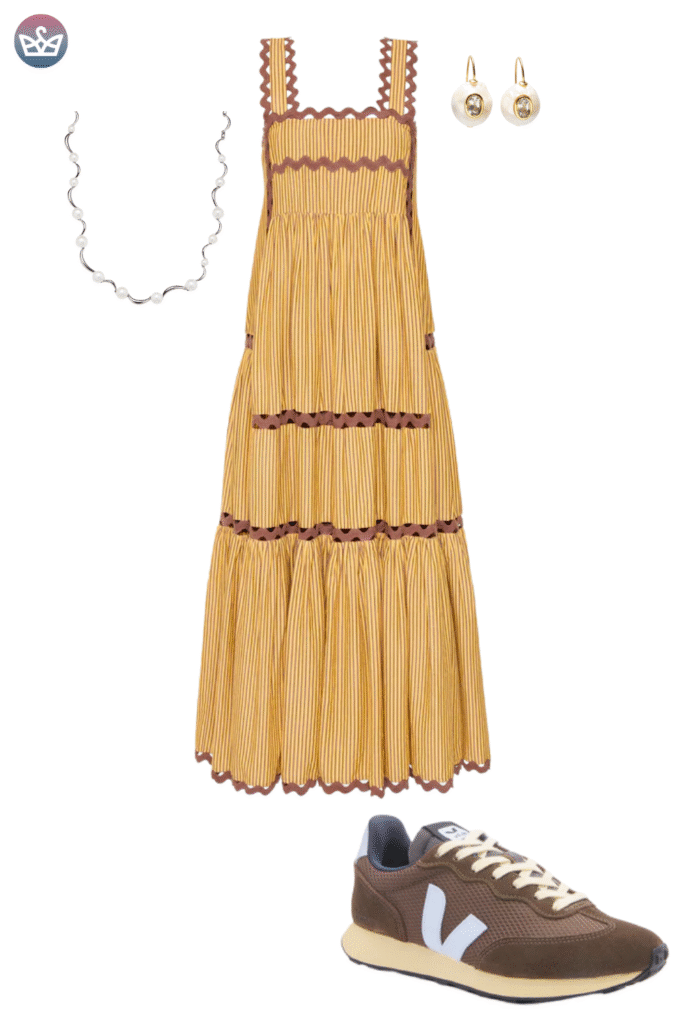 Unique bohemian fall outfit featuring a stunning tiered fringed straw colored maxi dress with subtle white edging Accessorized with simple gold hoop earrings and styled with brown and white retro sneakers and socks This look focuses on bringing comfort footwear to a dramatic dress silhouette for a casual autumn event