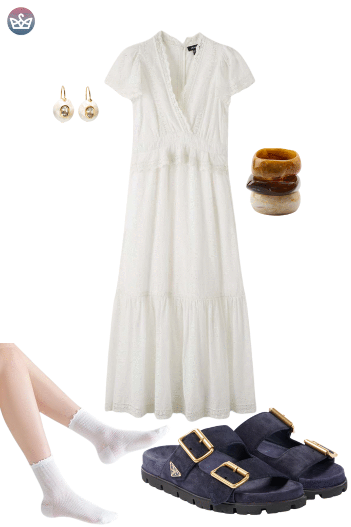 Flowy and elegant early fall outfit featuring a beautiful white tiered wrap maxi dress simple gold hoop earrings and stacked brown bangle bracelets The dress is styled with comfortable dark navy suede double strap sandals This look focuses on how easy walkable footwear can be styled for a comfortable yet fashionable autumn transition even with the addition of cozy socks