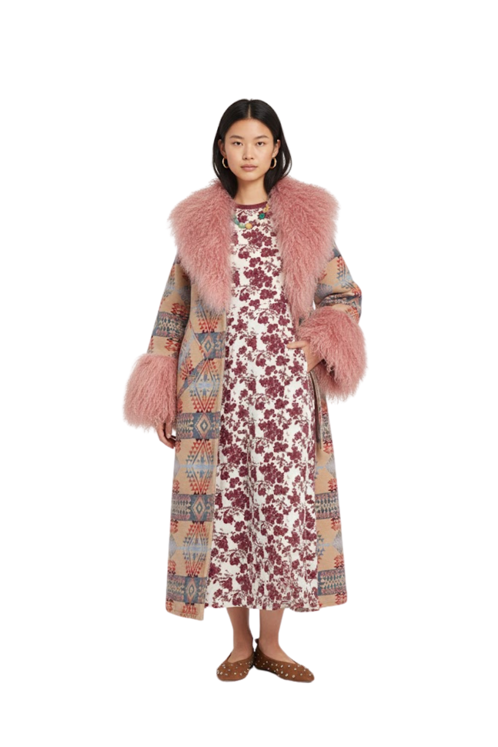 A woman showcases a mixed media black winter coat for women featuring a faux fur body and quilted sleeves The coat is styled over a brown animal print dress and paired with chunky white sneakers