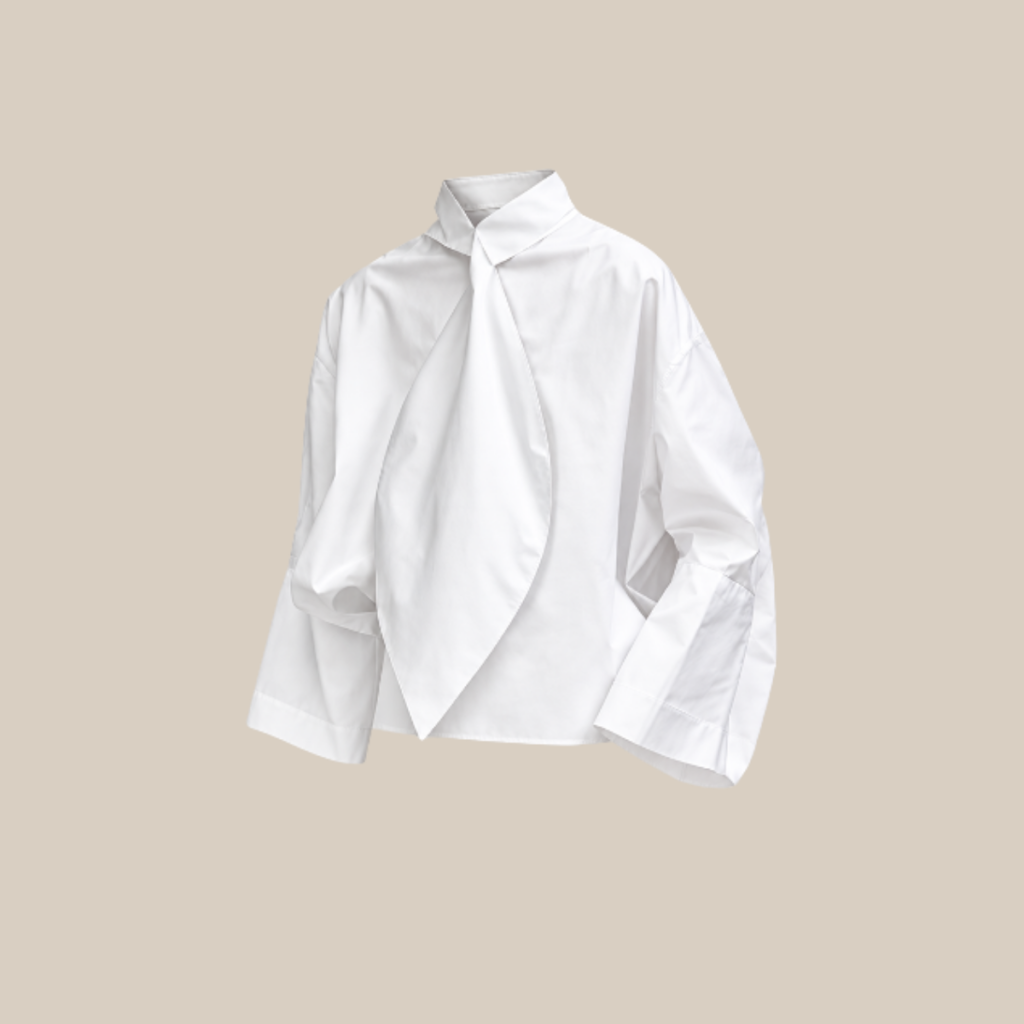 White oversized blouse with a twisted front drape and wide cuffs against a beige backdrop Tldr winter work outfits are easier with seven closet staples kick crop pants office shoes in the same color a button down a merino sweater a third piece weatherproof boots and a work tote Pair the pants and shoes in one color then build the top half around a button down and a merino sweater with a  adjust my crown